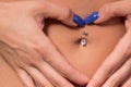 Woman with belly piercing making heart shape on belly Royalty Free Stock Photo