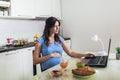 Woman with belly working as freelancer with laptop