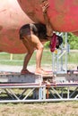 Woman Bends Low To Avoid Ball Obstacle At Mud Run