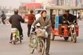 Woman with bicycle crossing the street in the chaotic traffic of Suzhou