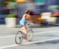 Woman on bicycle in motion riding down the street Royalty Free Stock Photo