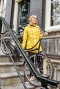 Woman with bicycle near the house entrance Royalty Free Stock Photo