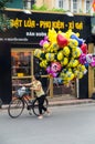 Woman on a bicycle selling Despicable Me helium balloons in Hanoi