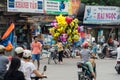 Woman on a bicycle selling Despicable Me helium balloons in Hanoi