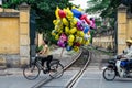 Woman on a bicycle selling Despicable Me helium balloons in Hanoi