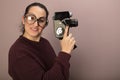 Woman with big glasses holding old film camera