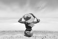 A woman with a big hat with a desert sea view watches flying crane birds coming home Royalty Free Stock Photo