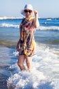 Woman in big straw sunhat and pareo sunbathing on a sandy beach near blue sea. Royalty Free Stock Photo