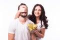 Woman with big toothy smile holding boyfriends eyes giving him a present for Valentine's day.