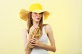 Woman in big yellow summer hat holds sandals Royalty Free Stock Photo