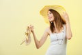 Woman in big yellow summer hat holds sandals Royalty Free Stock Photo