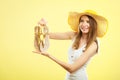 Woman in big yellow summer hat holds sandals Royalty Free Stock Photo