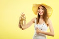 Woman in big yellow summer hat holds sandals Royalty Free Stock Photo