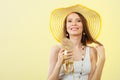 Woman in big yellow summer hat holds sandals Royalty Free Stock Photo