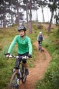 Woman, bike and cycling outdoor on trail for exercise, workout or adventure in forest with fitness. People, cyclists and