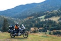Woman biker with big adventure motorbike, motorcyclists vacation, world traveler, long road trip on two wheels. autumn day.