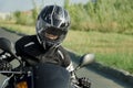 Woman biker in black motorcycle safety helmet driving a motorcycle. Active hobby, travel
