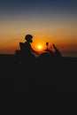 Woman biker silhouette over sunset, female riding motorcycle, motorbike driver traveling, lady look on the beach, freedom Royalty Free Stock Photo