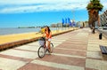 Woman biking on the boulevard along Pocitos beach in Montevideo, Uruguay.