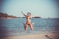 Woman in bikini on the beach jumping under water Royalty Free Stock Photo