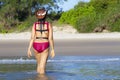 Woman and bikini crimson with hat walk on beach Royalty Free Stock Photo