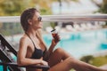 Woman in bikini drinking a cocktail on the terrace