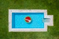 A woman in bikini floats on a watermelon shaped float in a pool Royalty Free Stock Photo