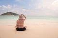 Woman bikini girl relaxing from behind wearing sun straw hat on beach looking at ocean in a tropical , Summer holiday travel Royalty Free Stock Photo