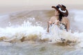 Woman with bikini and hat play wave on beach