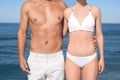Woman in bikini and her boyfriend on beach, closeup. Lovely couple