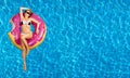 Woman in bikini on the inflatable mattress in the swimming pool.