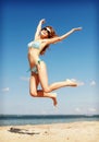 Woman in bikini jumping on the beach Royalty Free Stock Photo