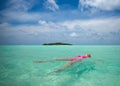 Woman in bikini lying on water at tropical beach Royalty Free Stock Photo