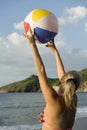 Woman in bikini playing with beachball on beach