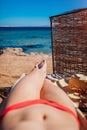 Woman in bikini relaxing on beach lying on chaise-longue with sea and mountain view. Summer vacation