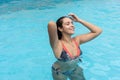 Woman in bikini relaxing at sunny summer poolside