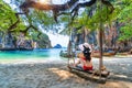 Woman in bikini relaxing on swing at Ko lao lading island, Krabi, Thailand