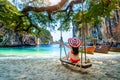 Woman in bikini relaxing on swing at Ko lao lading island, Krabi, Thailand