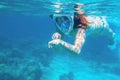 Woman in bikini show time underwater. Snorkeling in tropical sea coral reef. Young girl in full-face snorkeling mask Royalty Free Stock Photo