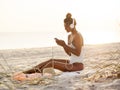 Woman in Bikini with a Smartphone and Headphones on the Beach Royalty Free Stock Photo