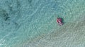 woman in bikini sunbathing as laying on swim ring as blue sea water in background