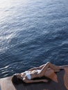 Woman In Bikini Sunbathing On Yacht's Floorboard Royalty Free Stock Photo