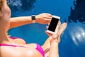 Woman using smartwatch and mobile phone by the pool Royalty Free Stock Photo