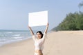 Woman In Bikinis Holding Blank White Board On The Beach