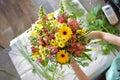 Woman binds flower bouquet in florist