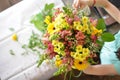Woman binds flower bouquet in florist