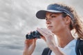 Woman, binoculars and hiking in nature, travel or outdoors vacation, holiday or trip in Canada. Freedom, cloudy sky and