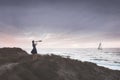 Woman with binoculars observes the infinite ocean , concept of freedom and travel Royalty Free Stock Photo