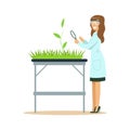 Woman biologist looking at green plant through magnifying glass