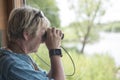 Woman bird watching looking through a pair of binoculars